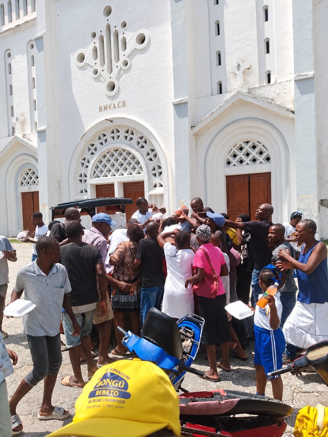 A crowd receiving hot meals in front of a church in Haiti
