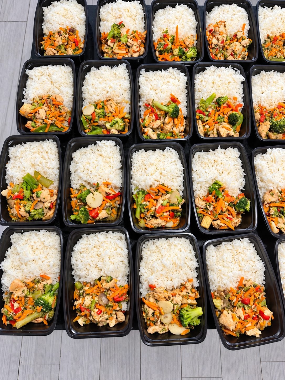 Trays of white rice with chicken and mixed vegetables